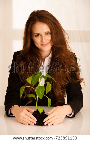 attractive business woman with seedling, growth and prosperity conceptual photo
