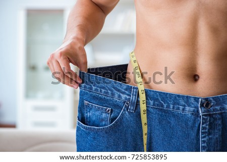Man in oversized pants in weight loss concept Royalty-Free Stock Photo #725853895