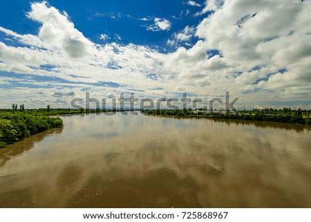 Landscape waterscape with industrial manufacturing transportation background under puffy clouds with blue sky