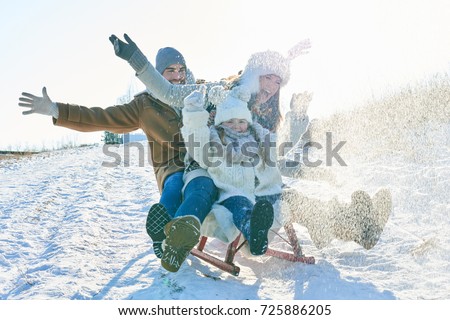 Family driving sled on the snow and having fun in winter Royalty-Free Stock Photo #725886205