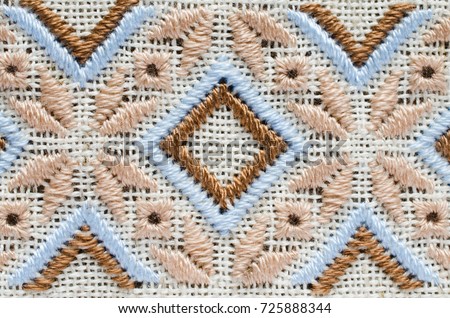 Element handmade embroidery on linen by brown and beige cotton threads. Craft embroidery. Design of ethnic pattern. Royalty-Free Stock Photo #725888344