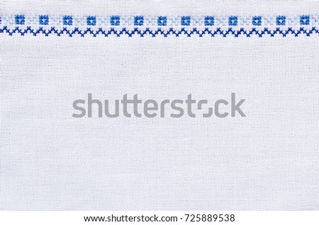 Slavic cross stitch by white and blue threads. Design of ethnic pattern. Embroidery texture for background. Royalty-Free Stock Photo #725889538
