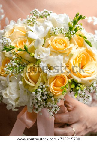 Bouquet of flowers of the bride. The bride holds a wedding bouquet of flowers in her hands. Wedding bouquet of flowers in ivory colours.