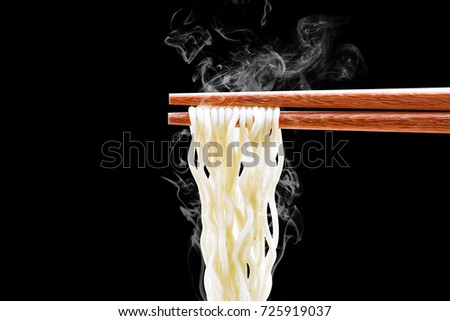 chopsticks noodles with smoke isolated on black background with clipping path