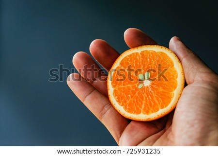 Close focus of hand holding orange fruit with copy space for text or advertising