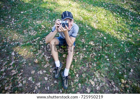 Funny man with a funny surprise expression shooting with his vintage reflex photo camera