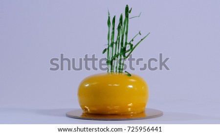 Contemporary Yellow Mousse Cake decorated with green caramel, on white background