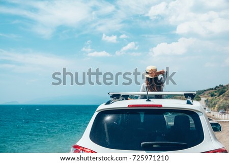 Rear view of pre teen child in car over sea view on summer roadtrip to the beach  Royalty-Free Stock Photo #725971210