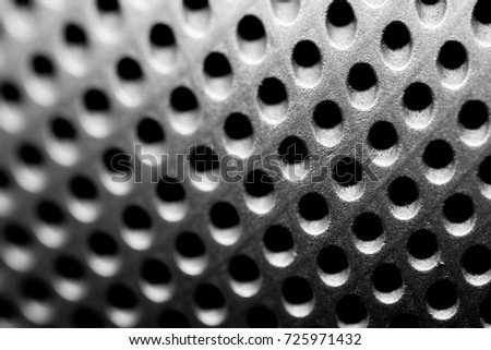 Abstract close up macro perforated dot holes texture in black and white. 