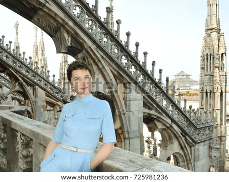Young and happy female traveler, view from the top of Duomo cathedral in Milan