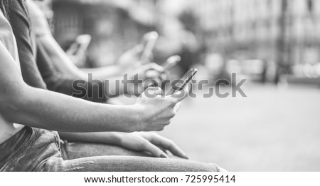 Group of teenagers friends watching mobile phones in city - Young people addiction to technology trends - Alienation moment for new generation problem - Focus on first hand - Vintage retro filter  Royalty-Free Stock Photo #725995414