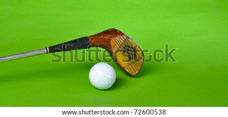 Golf ball and club isolated on green background with copy space