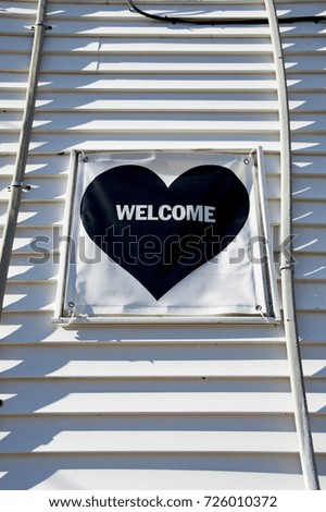 Welcome Word In Heart Shape On Side Of Building