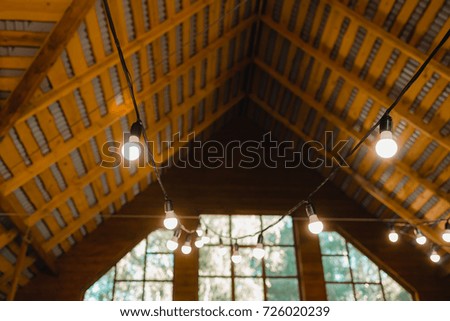 Garland of light bulbs hanging under the ceiling in a wooden house