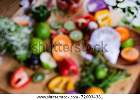 Out of focus. Colourful of very much fruits on table. Chili, apple, orange, vegetables, pimento, tomatoes and more on table in the kitchen
