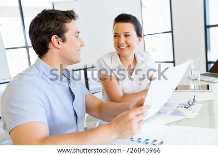Image of two young business people in office