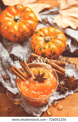 Food and drink, still life, thanksgiving harvest fall autumn concept. Pumpkin jam or confiture with spices on a rustic wooden table. Toned image