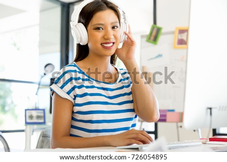 Young woman in office with headphones