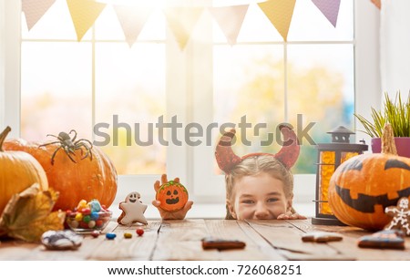 Cute little child girl with sweets at Halloween.