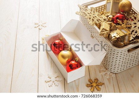 unpacking box with christmas gold red toys balls and stars new year white wooden table  background decorations