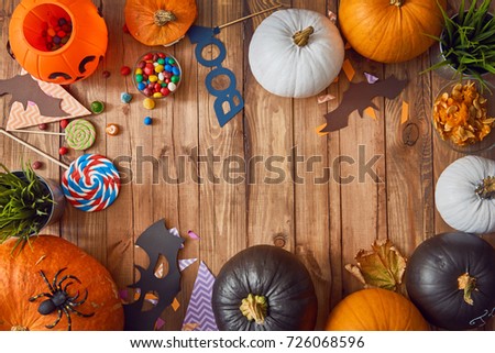 Happy halloween! Carving pumpkin, candy, paper bats on the table in the home. Preparing for holiday.