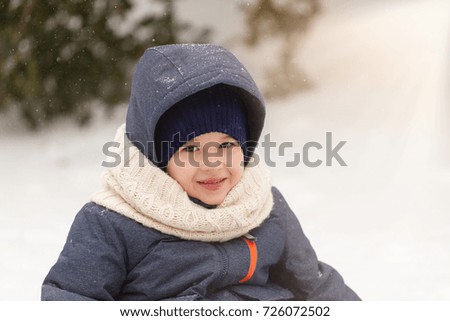 Happy little boy in winter snow