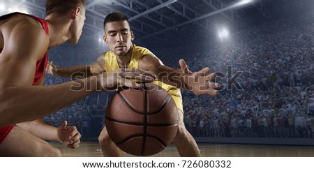 Basketball players on big professional arena during the game. Players fight for the ball. Players wears unbranded clothes.