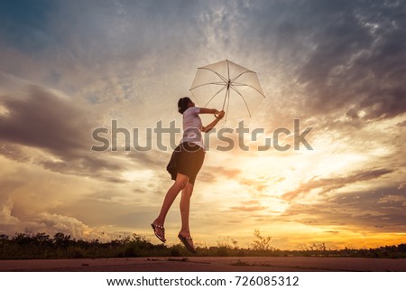 Silhouettes of freedom women and umbrellas on sunset background