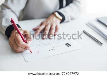 Hands of cropped woman teacher grading tests at school. Royalty-Free Stock Photo #726097972