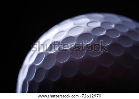 A close-up of a golf ball over dark background