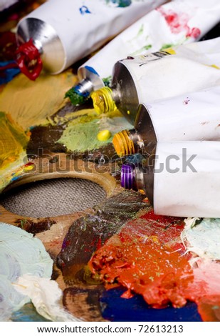 Artistic equipment: paint, brushes and knives on paint background