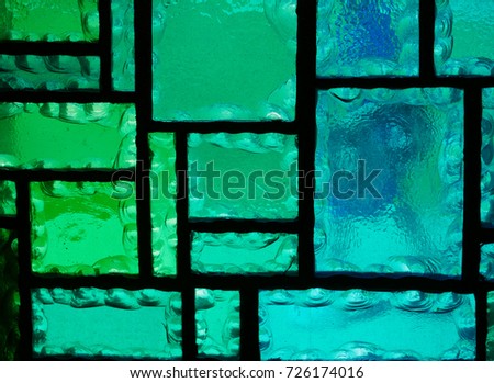 Detail of a stain glass window in green and blue