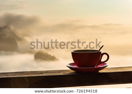 Cup of Coffee on Wood Floor with Misty and Mountain Background.Thailand