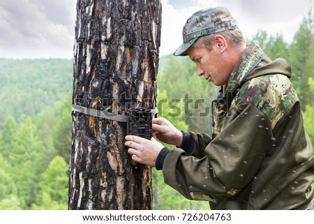 Camera traps with infrared light and a motion detector attached by straps on a tree photograph animals in the Siberian taiga.
Foresters install photo traps 