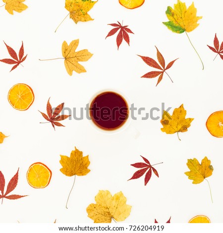 Autumn round composition of autumn colorful maple leaves and cup of tea on white background. Flat lay, top view.