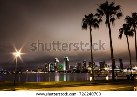 Long exposure capture of San Diego bay with the city skyline lighted in the background.
