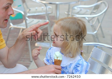 girl and his father in outdoor cafe eating Ice-cream