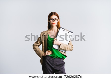 serious secretary girl holding herself at the waist with a file in her hand on a white background
