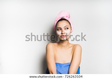 pensive girl with a towel tied around her head with a mask on her face