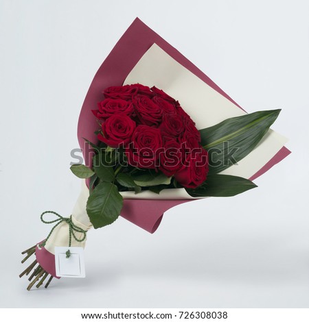 Bouquet of beautiful flowers roses in colorful packaging on a gray background