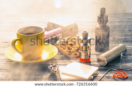 Still life with electronic cigarette with botle and coffe on the wooden background