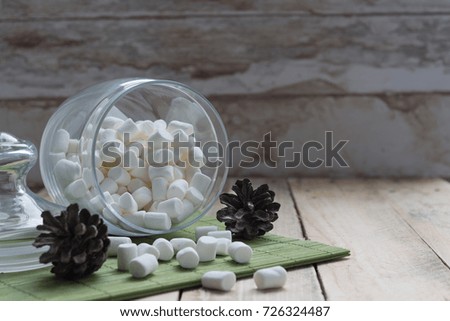 marshmallow pouring out of jars.wooden background. selective focus.