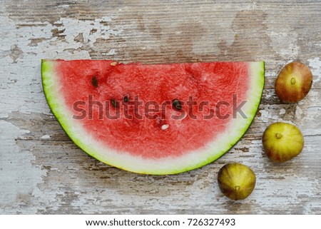 slice of watermelon and figs on a wooden table.