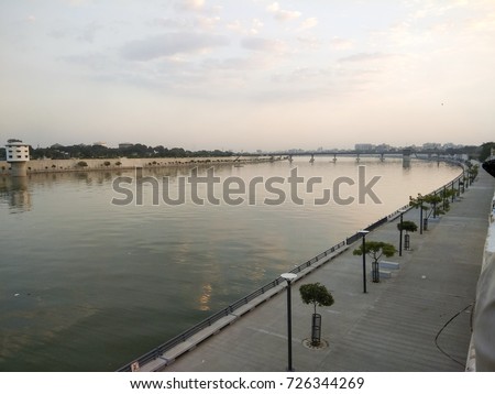 Sabarmati Riverfront, Ahmedabad, Gujarat, India - People walk on pathway near the river. This place is calm and composed and is the heart of the city. Ahmedabad is the World heritage city as well. Royalty-Free Stock Photo #726344269