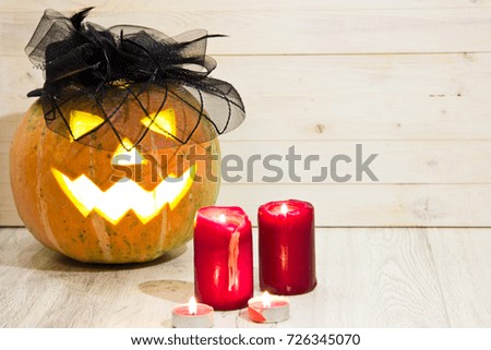 Halloween Pumpkin, funny Jack O'Lantern on wood background  with candle light inside