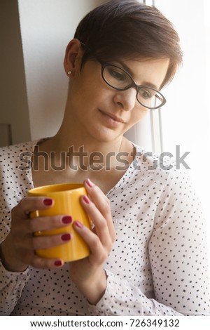 young woman with short hair drinking coffee