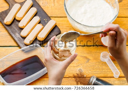 Image on top of wooden table with biscuits, human hands