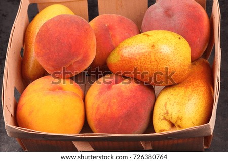 Yellow pears and orange peaches in a wooden basket with Christmas tree branches for Christmas dinner