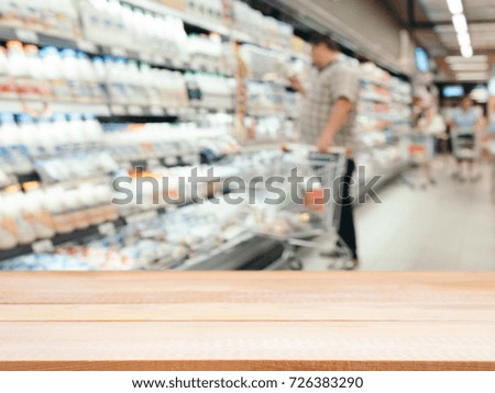 Light wooden board empty table in front of blurred background. Perspective table over blur in supermarket - can be used for display or montage your products. Mockup for display of product.