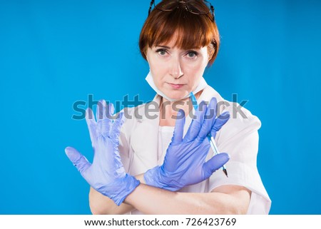 An angry lady in medical clothes holds an injection in her hands and shows a sign of prohibition